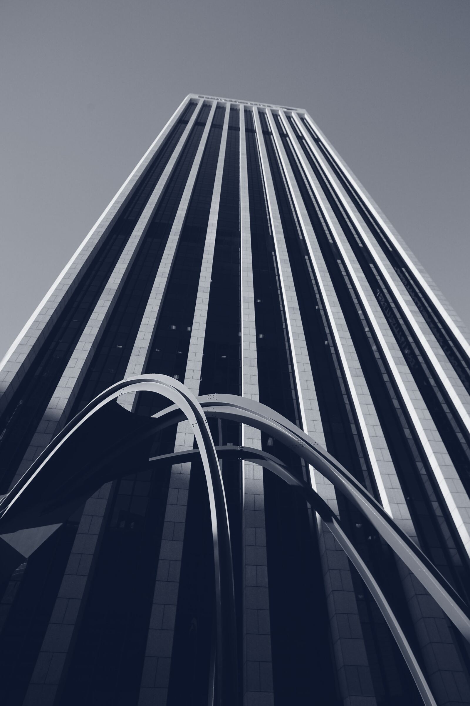Black-and-white view of a glass skyscraper seen from below